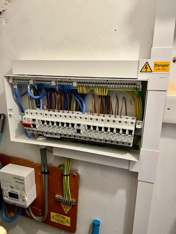 Electrician fitting a consumer unit during emergency electrical work